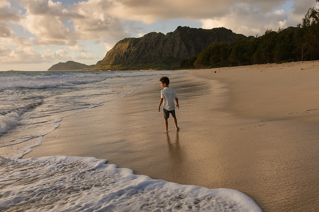 boy playing in the surf on the windward coast of oahu during a family photoshoot by little bird photography