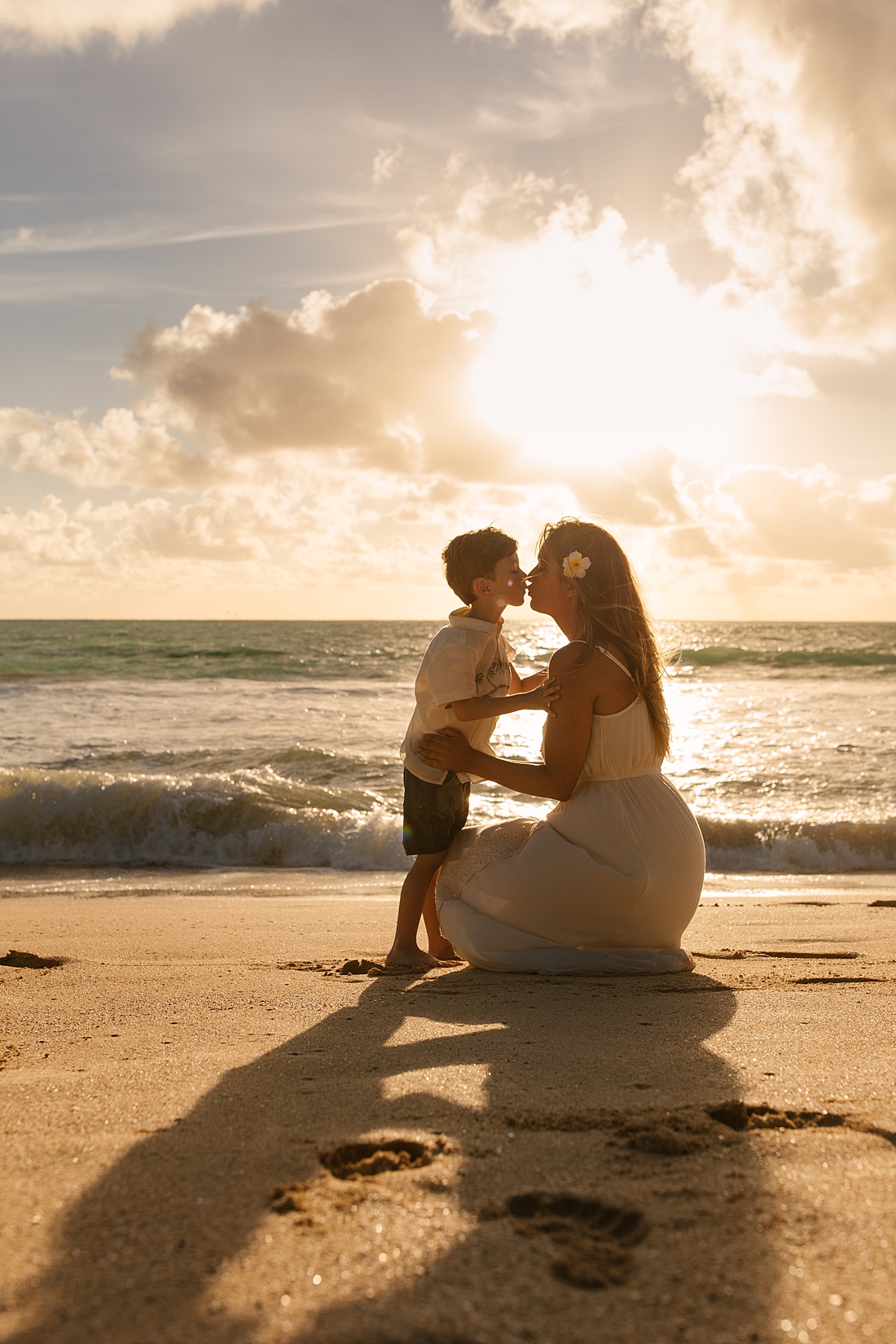 mom and son kiss during a sweet Oahu family photo shoot