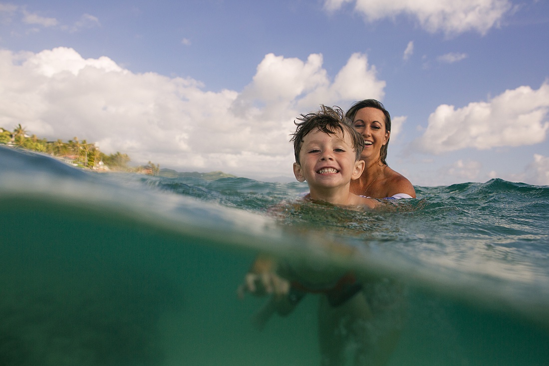 mom and son swimming in the clear blue waters of lanikai beach by little bird photography