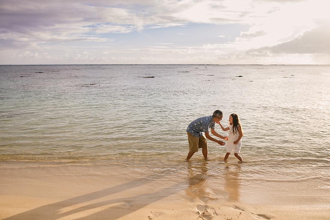 dad and daughter playing at lanikai beach at sunrise for family portraits