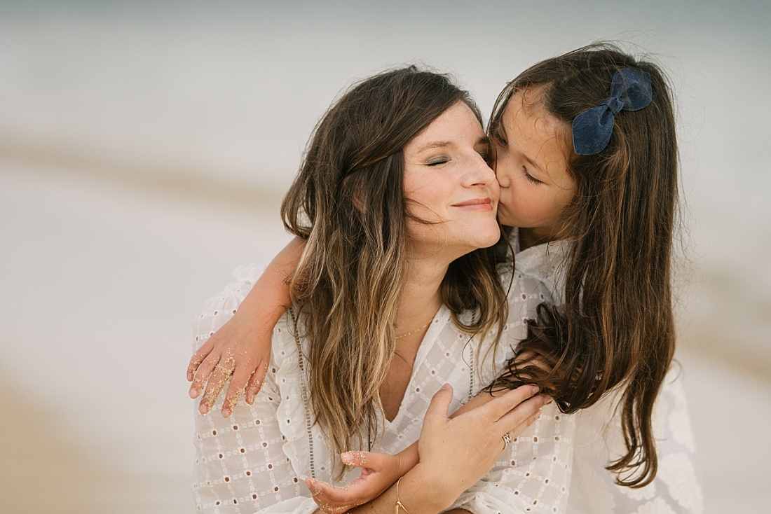 mom and daughter snuggle during a hawaii photo session