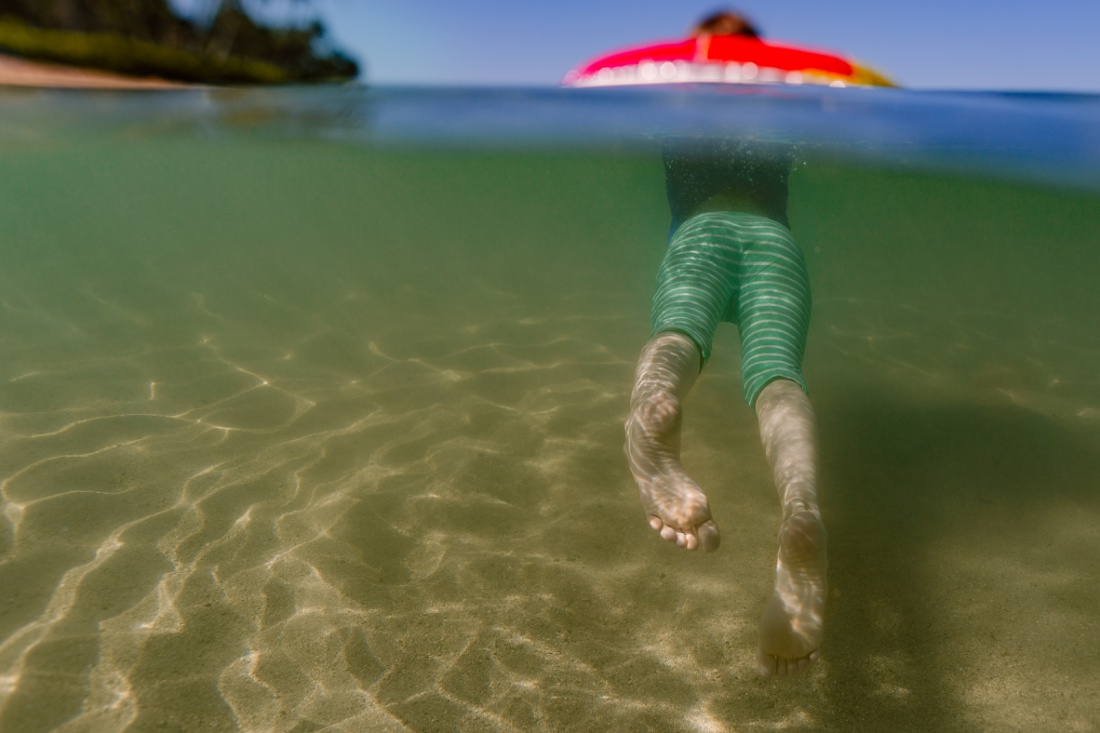 underwater portrait of a girl floating on an intertube in paradise cove