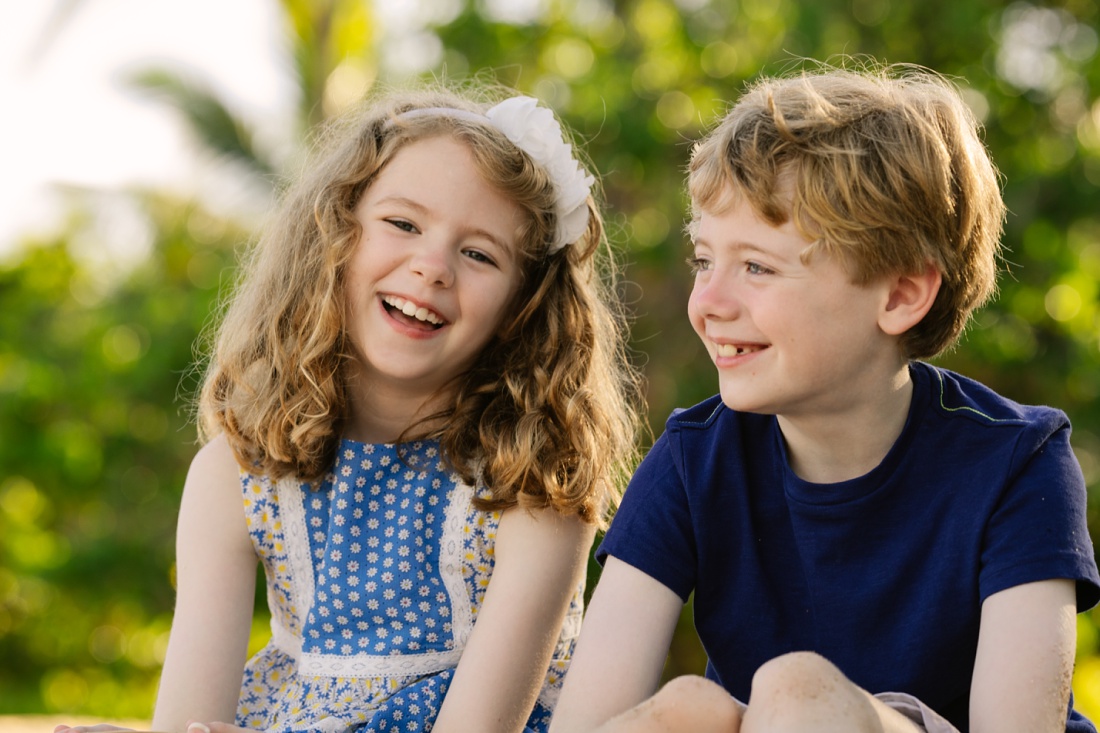 twin siblings sharing a laugh during a portrait session in oahu