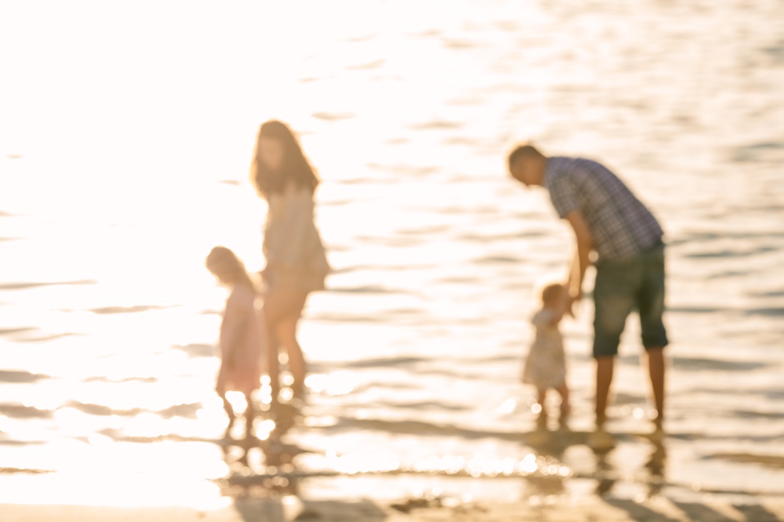family out of focus in shimmering light of sunrise