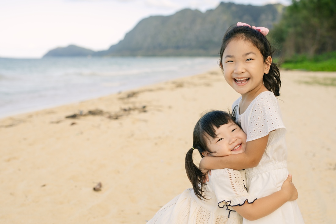 sisters hugging during a family photo session in oahu