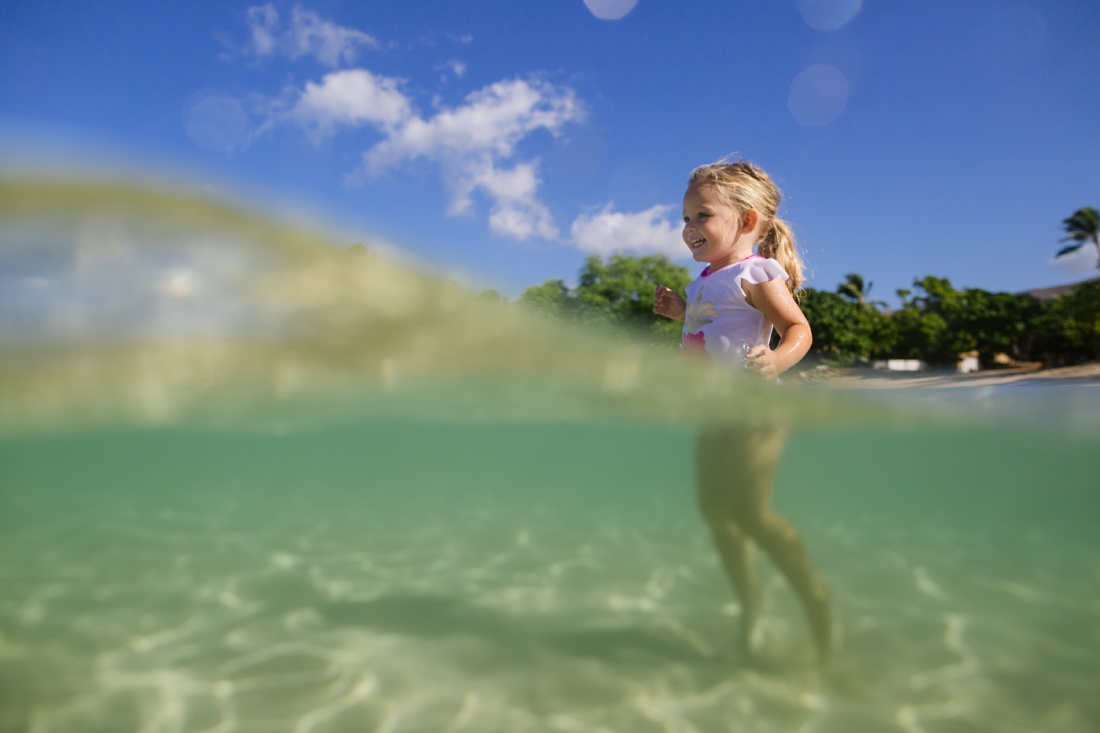 portrait of a laughing girl playing in the water at koolina