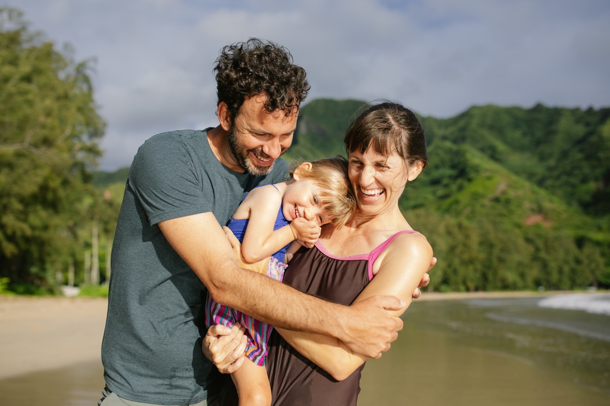 family hug during a photo session at kahana bay oahu
