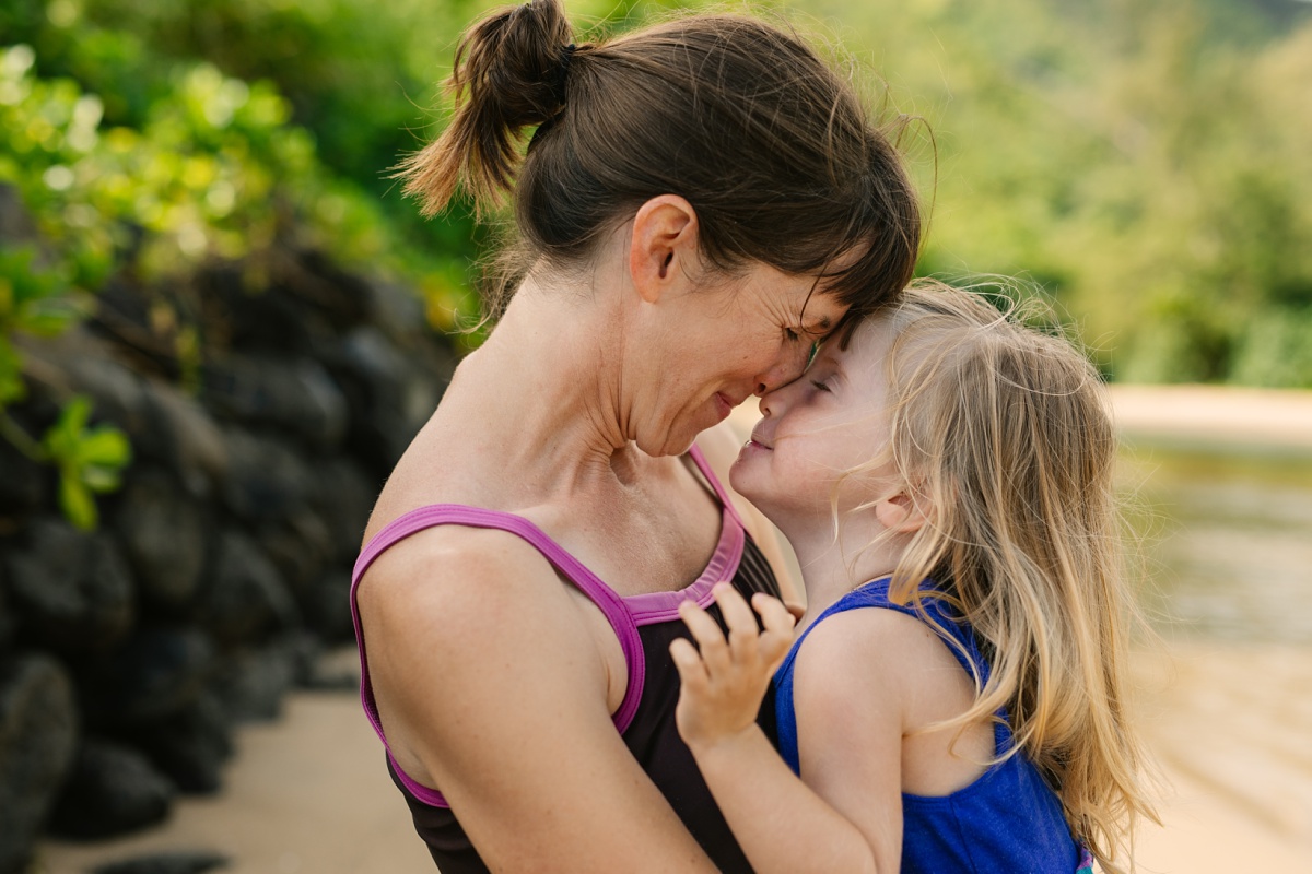 mom and daughter touch noses during a fun family photo session in hawaii