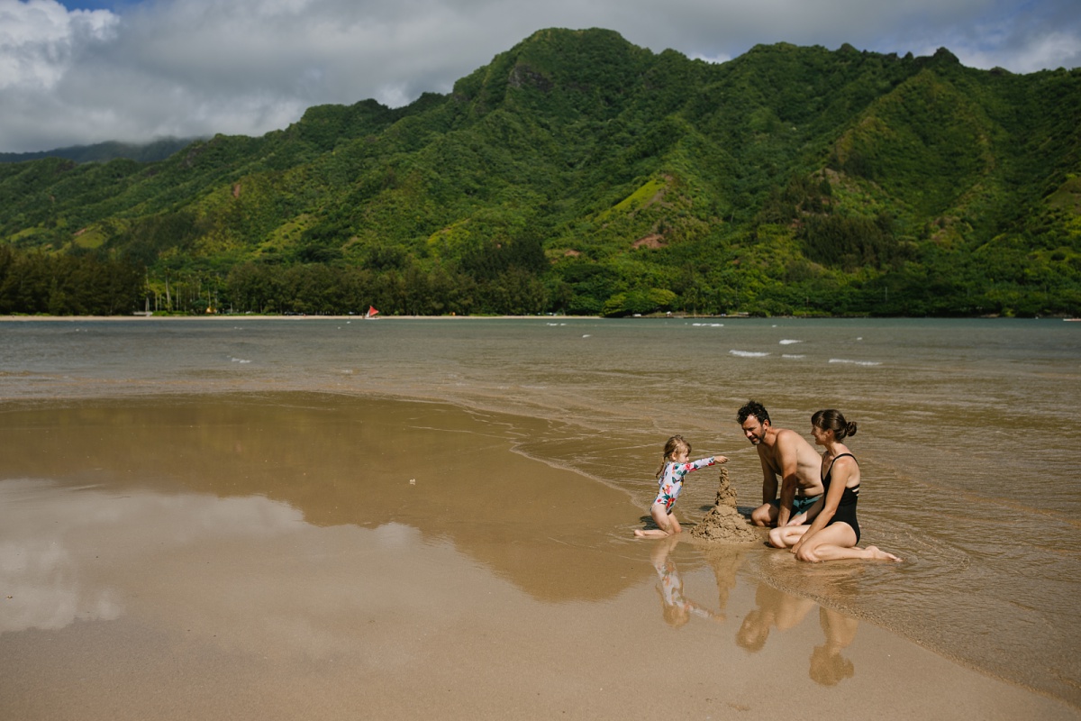 family building sand castles together at kahana beach hawaii