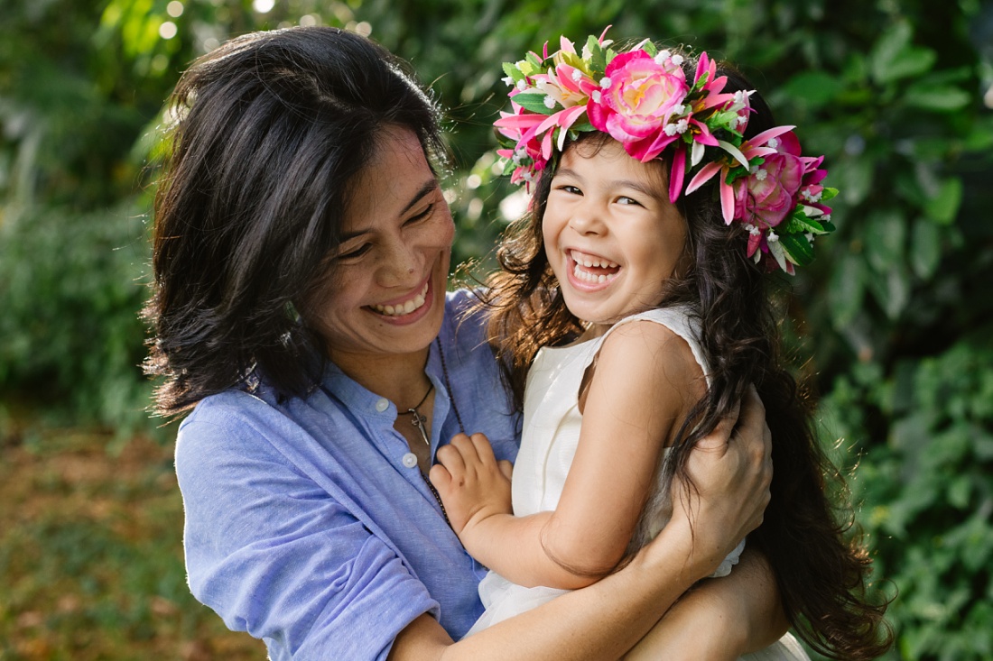 portrait of laughing mom and daughter wearing haku lei in hawaii
