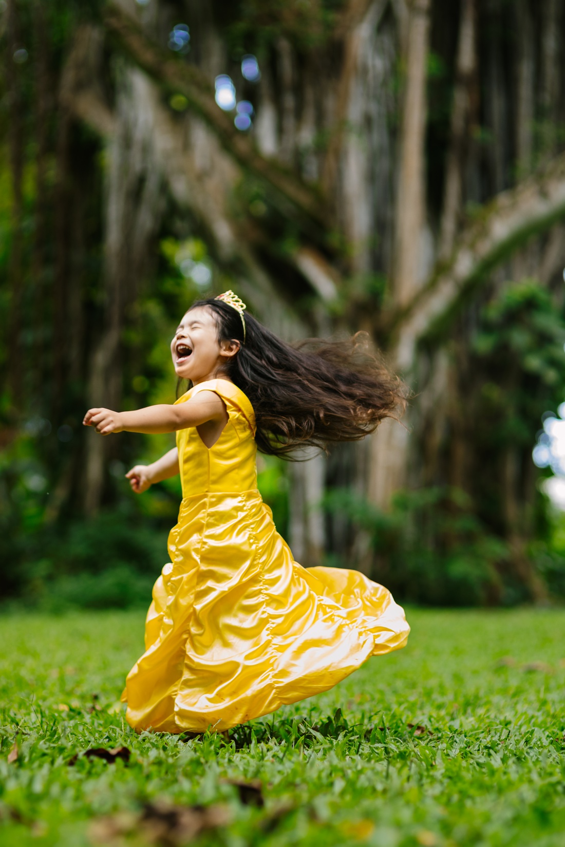 happy girl spinning in nuuanu park wearing a belle dress