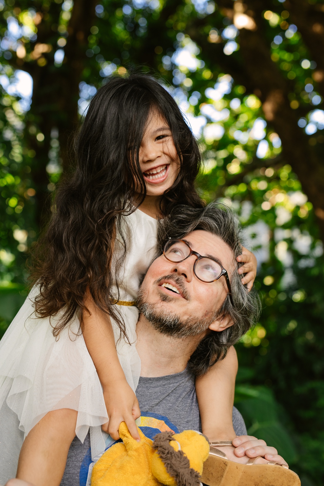 girl sitting on dads shoulders during a hwaii photo session at nuuanu valley park