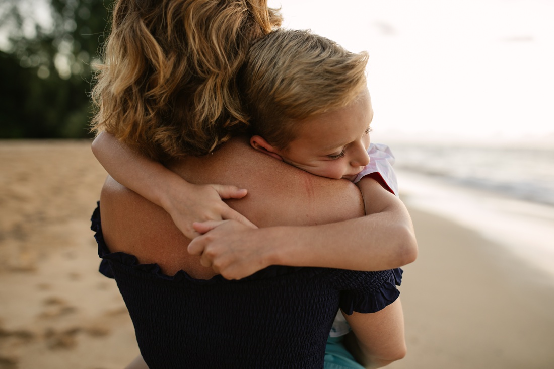 little boy hugging his mom during a family beach photoshoot