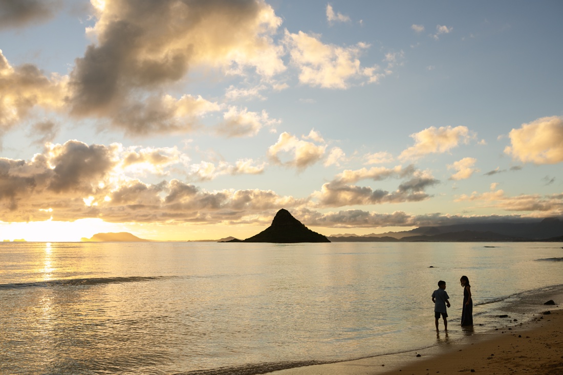 twin siblings play along the shore at sunrise during a hawaii family photo session