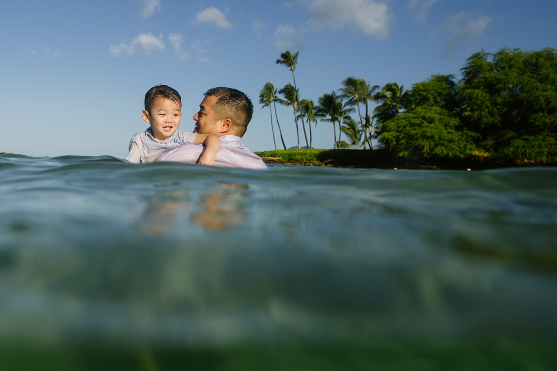 dad and son playing in the water in hawaii