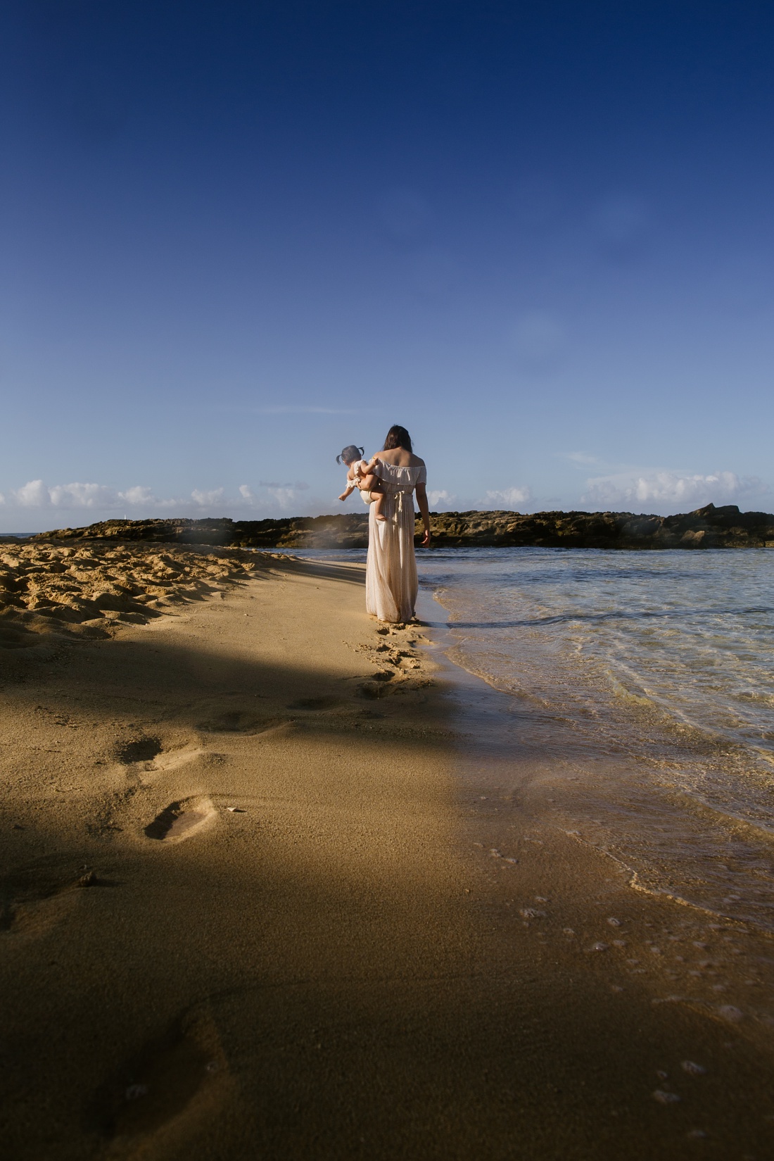 mom walking on the beach in hawaii with toddler girl by little bird photography