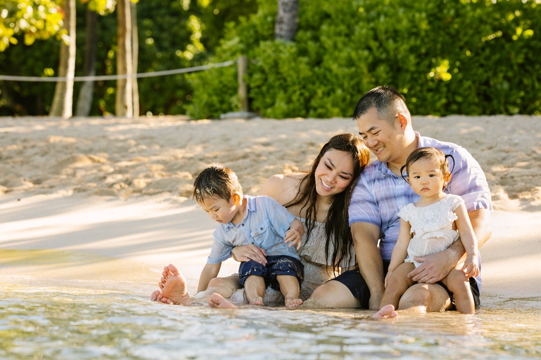 family cuddling at the edge of the water during a family photo session