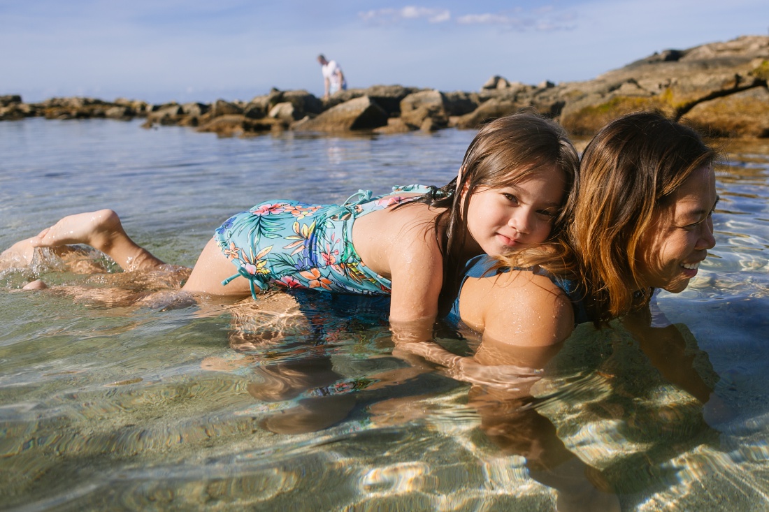 portrait of a girl and her mom in the water of paradise cove in koolina lagoon