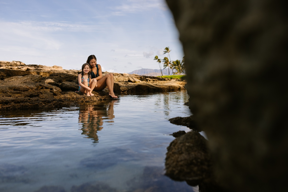 mom and daughter looking for fish during a fun family photo session in hawaii