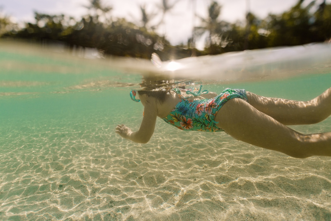 girl swimming under water in hawaii
