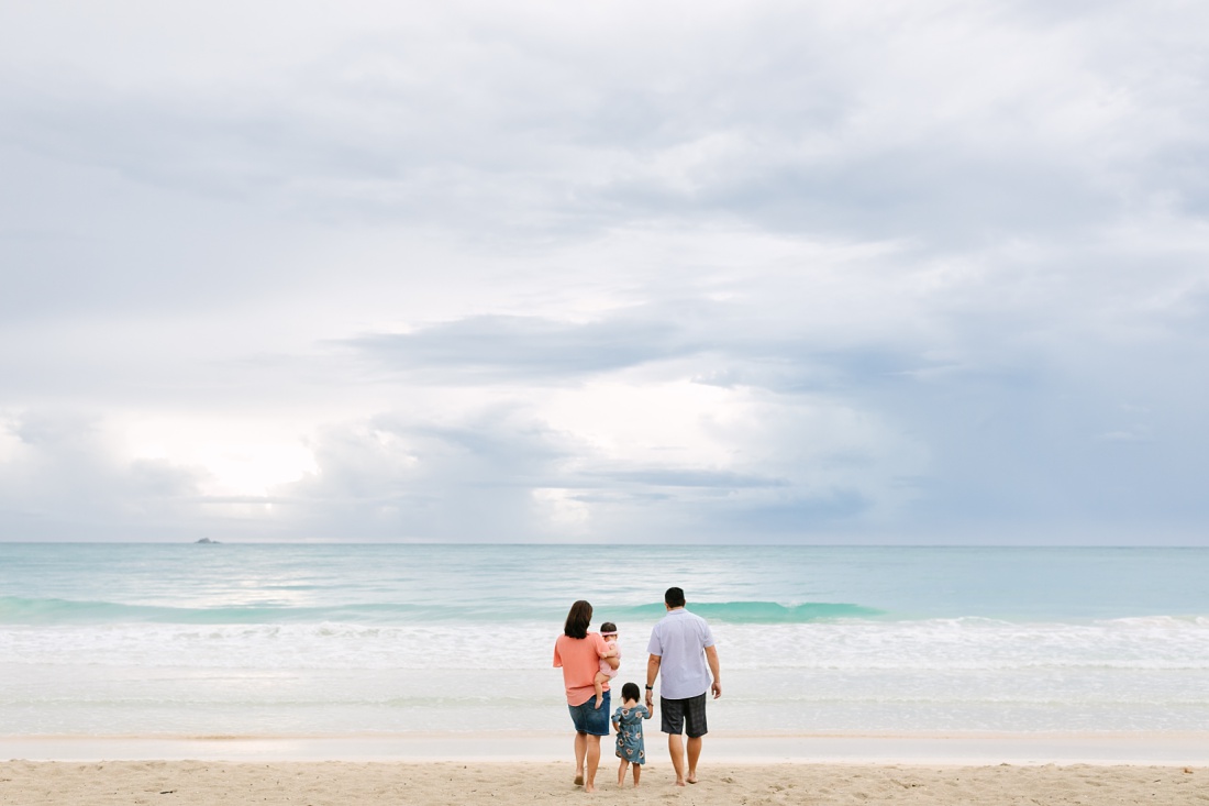 family walking toward the ocean at kalama beach in kailua oahu