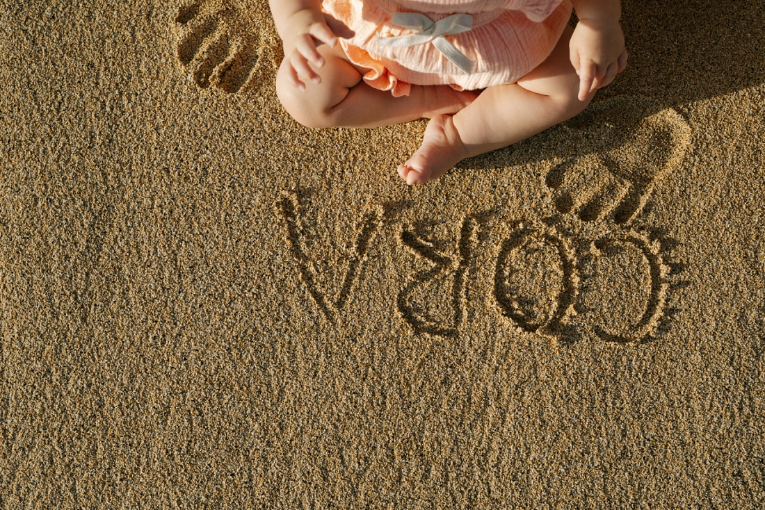 writing in the sand with baby feet