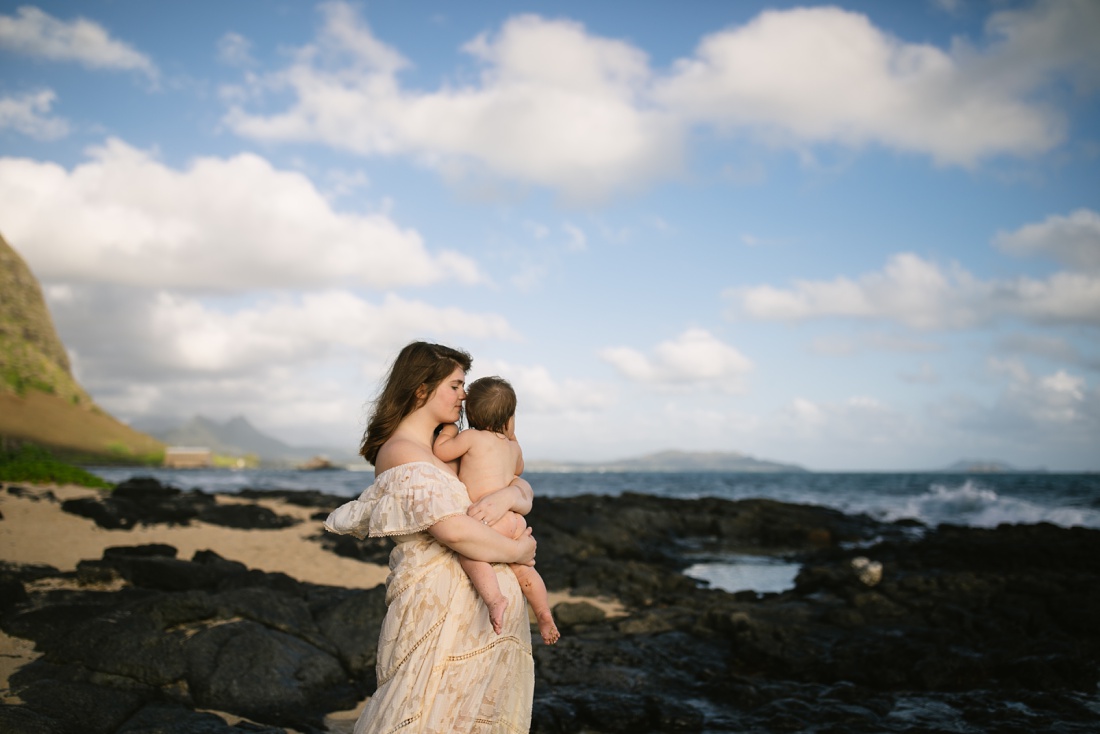 mom holding baby during a beach photo session at Makapuu Beach
