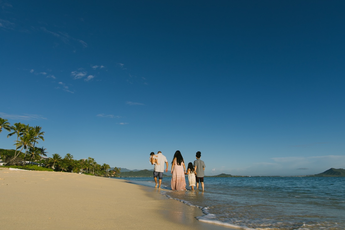 family walking along the shore at lanikai beach kailua