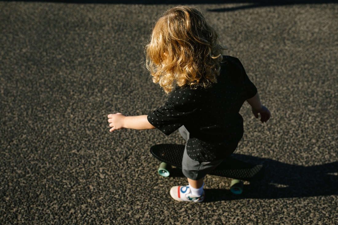 curly haired toddler on a skateboard during a family photography session in oahu