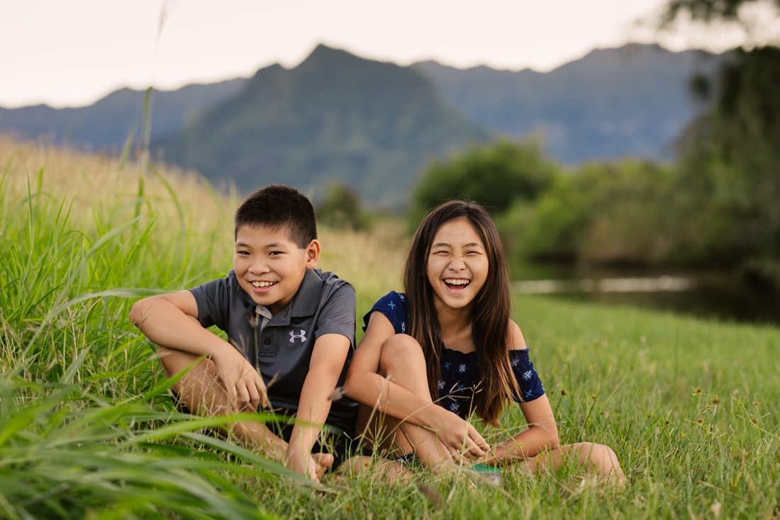 siblings share a laugh during a oahu child portraits session in kailua