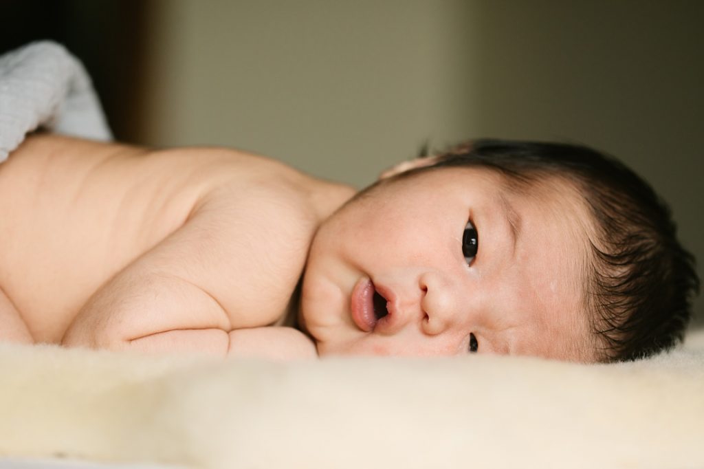 closeup portrait of newborn baby with open eyes