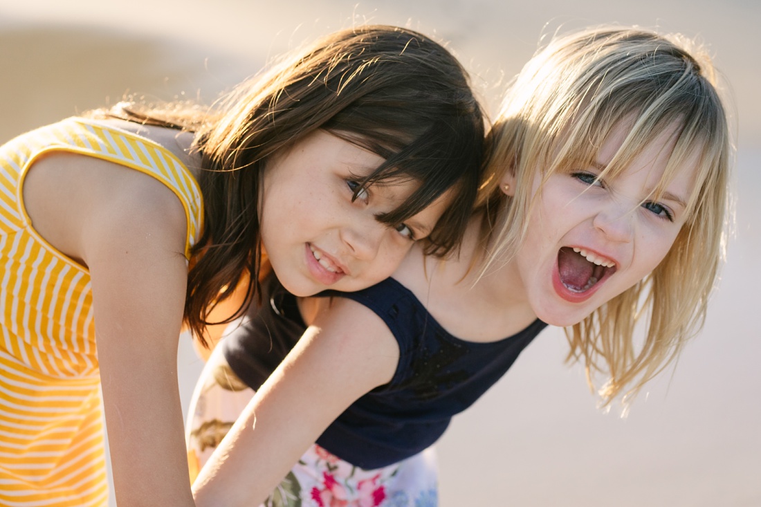 sisters play together during a hawaii family photo session by little bird photography