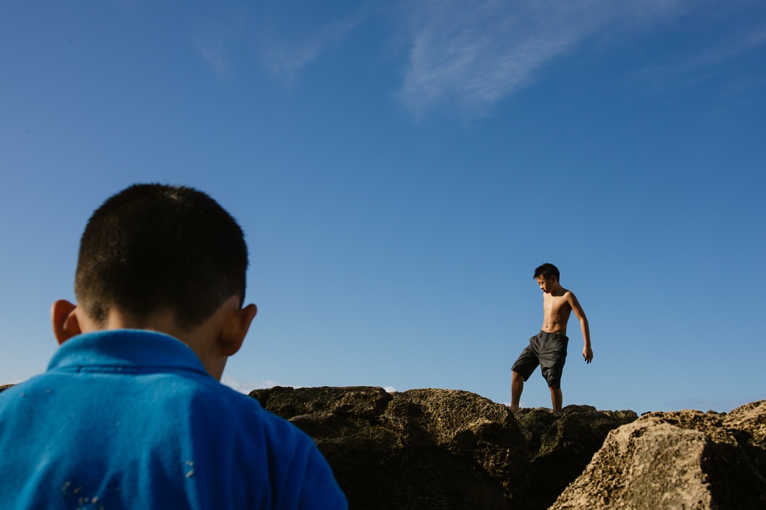 brothers explore the rocky intertidal area during a family photo shoot in hawaii