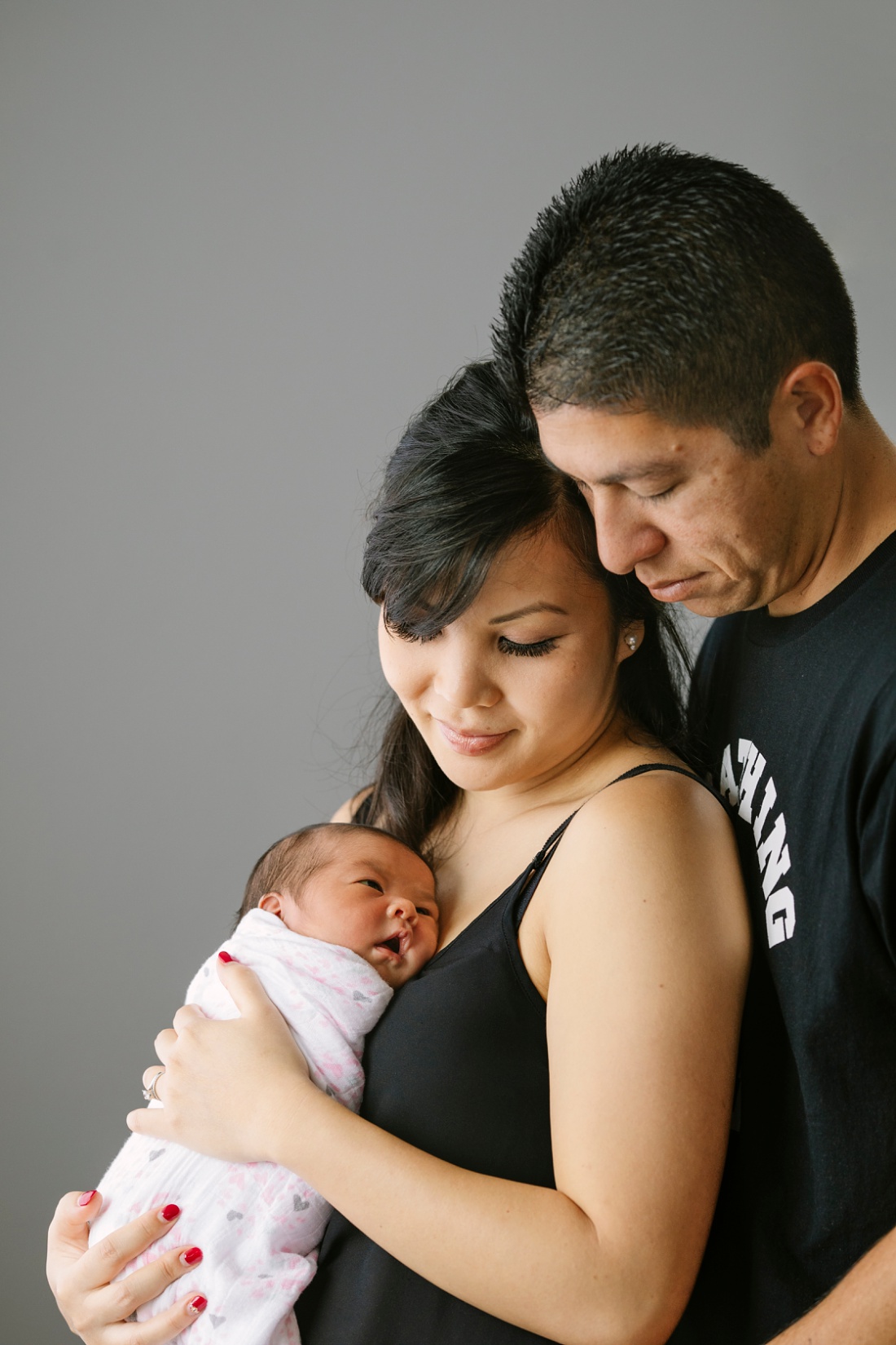 couple snuggling their newborn baby during a family photo session in hawaii