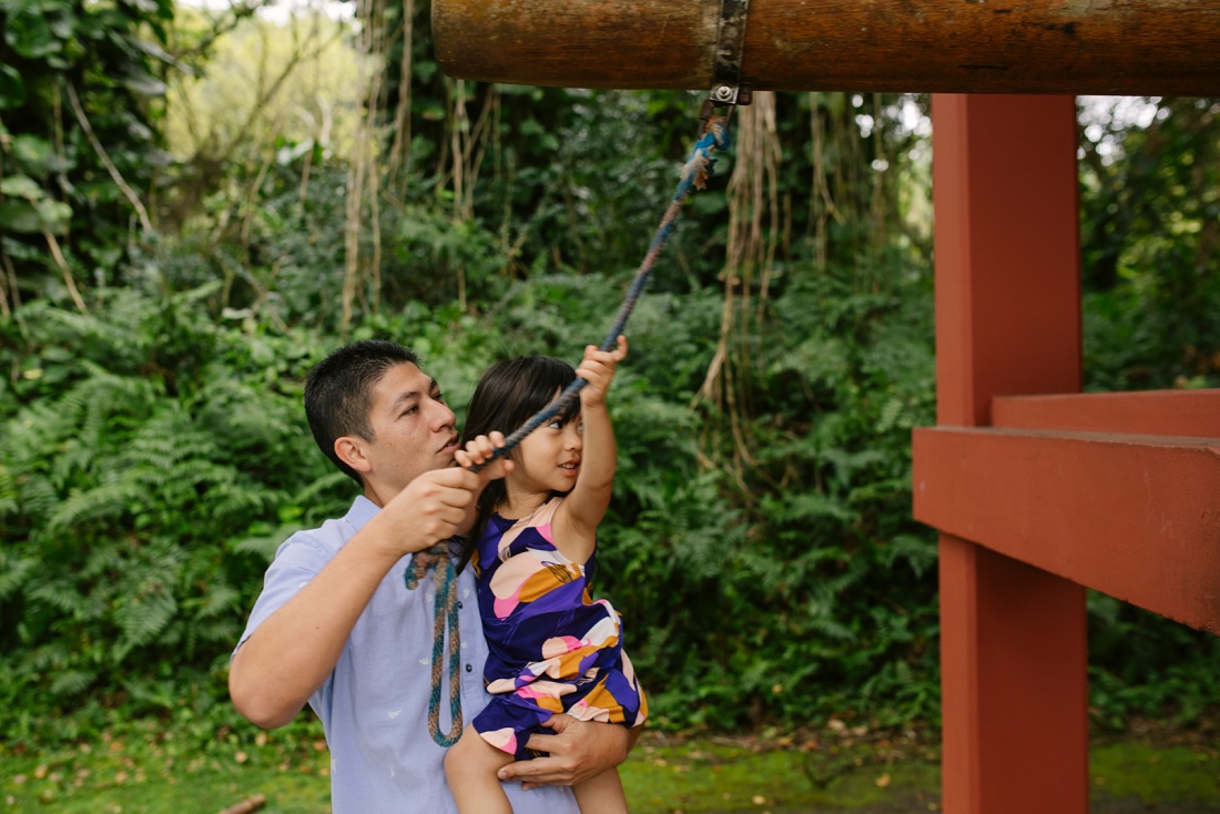 dad and daughter sound the bell at byodo-in temple