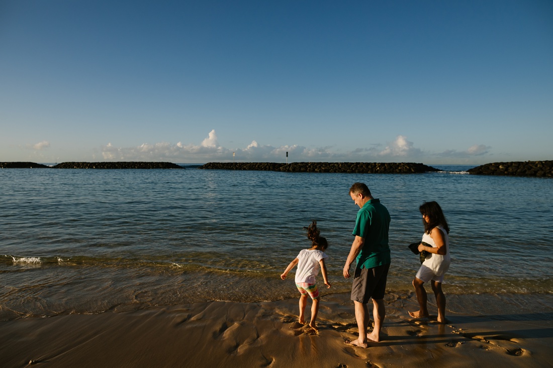 family splashes at magic island beach outside waikiki