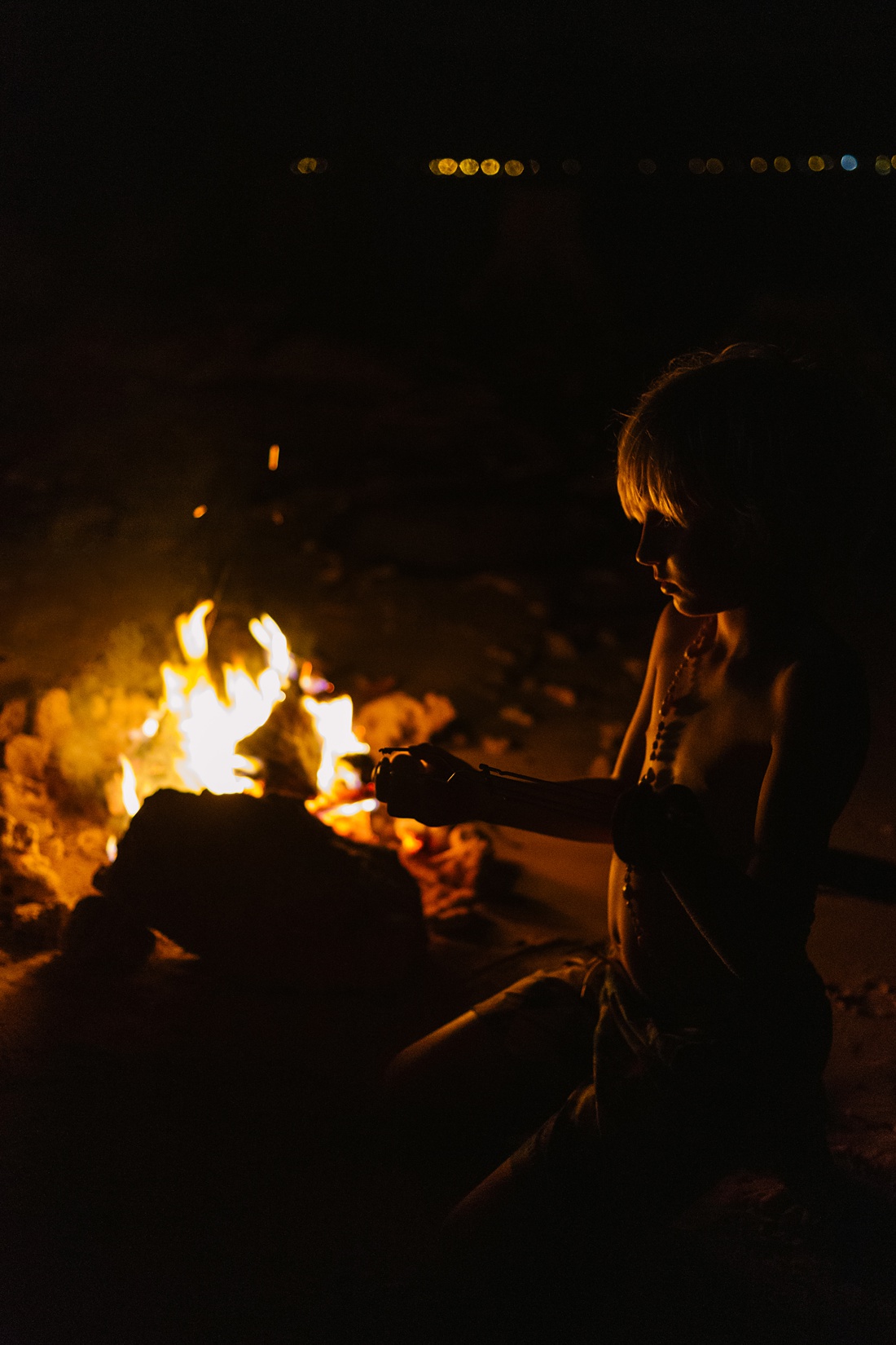 boy at a campfire in hawaii
