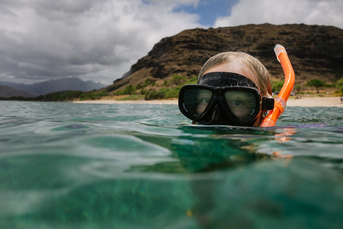 closeup of girl snorkeling at electric beach in oahu, hawaii