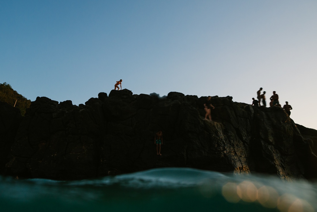 girl making her way to the top of the jumping rock at waimea bay