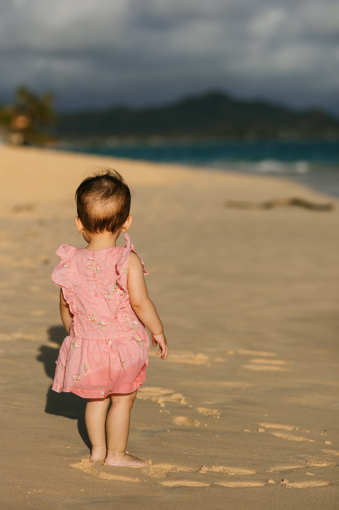 baby girl standing on the beach in hawaii