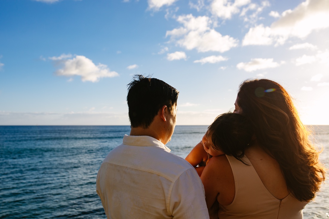 family looks out at the ocean before sunset in oahu