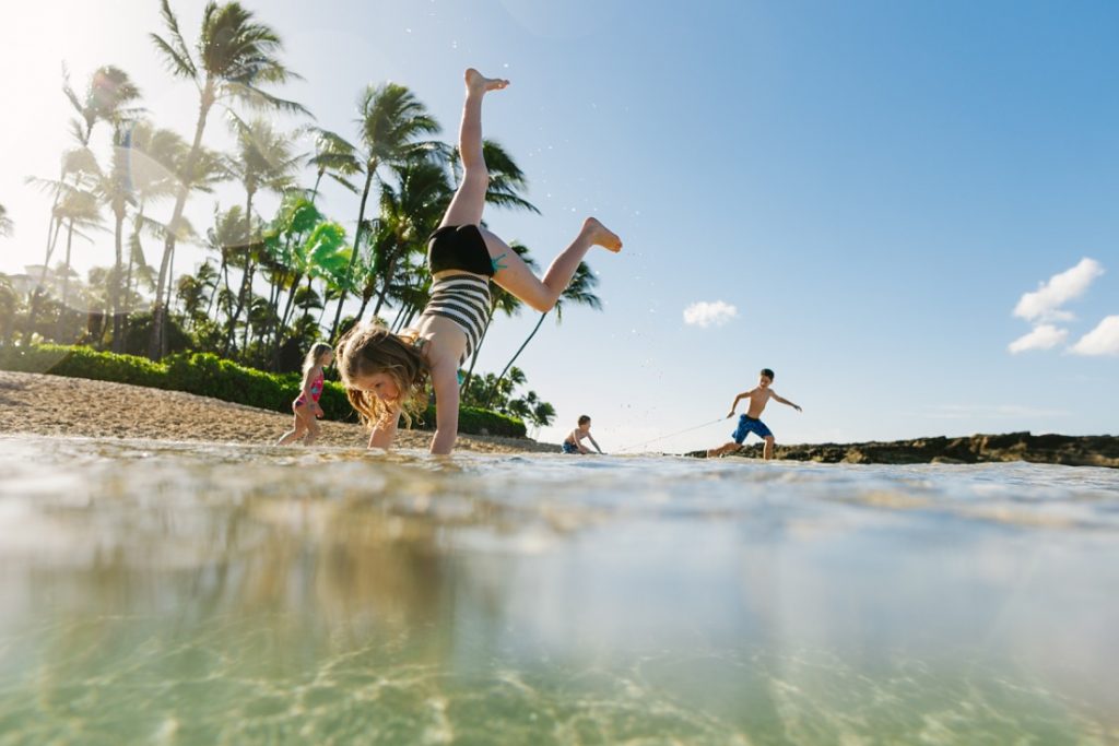 oahu family photographer captures 4 siblings playing at paradise cove oahu