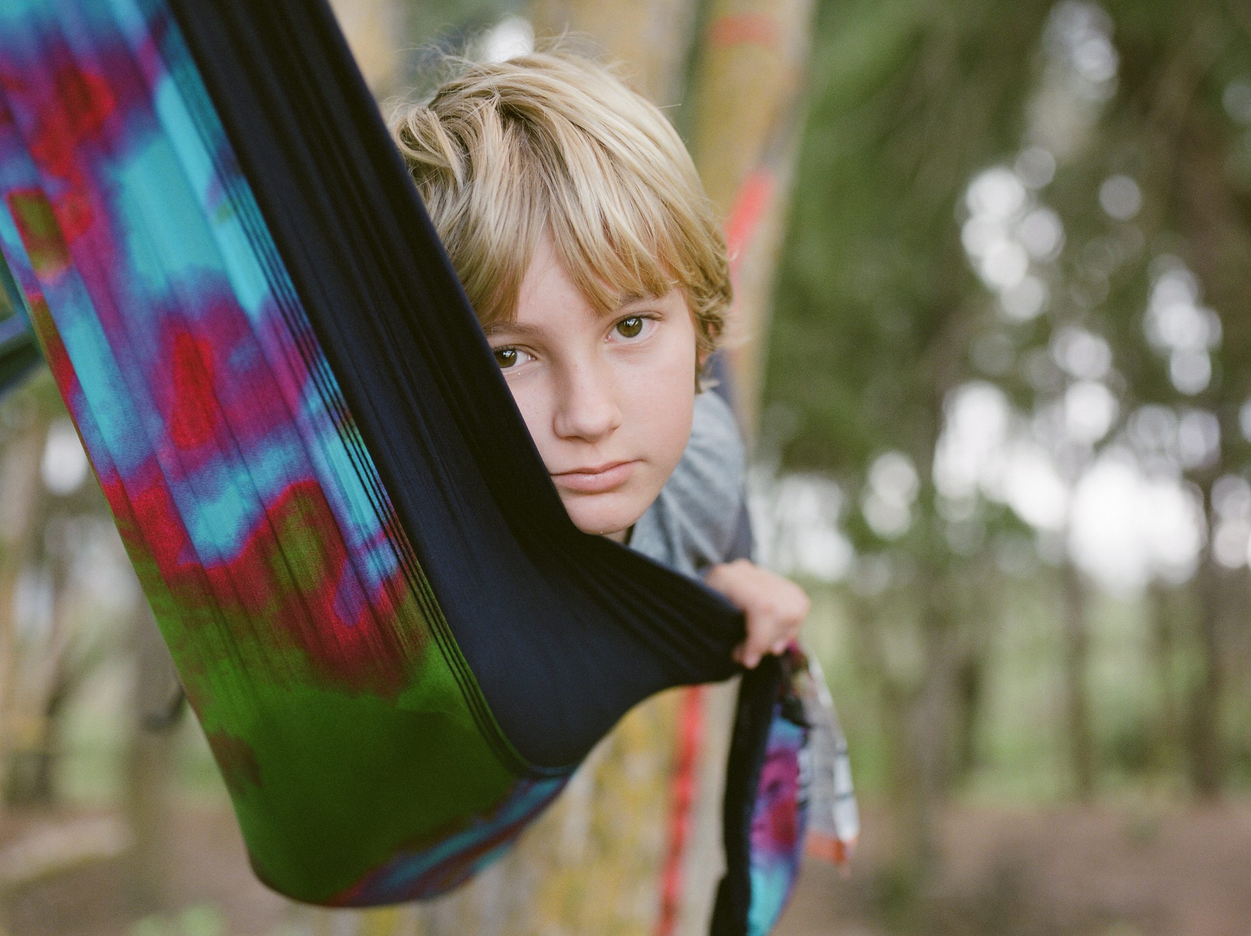 boy in a hammock at waimanalo beach in oahu