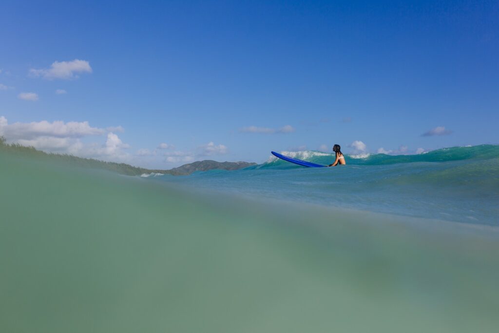 girl surfing at sherwood beach in waimanalo