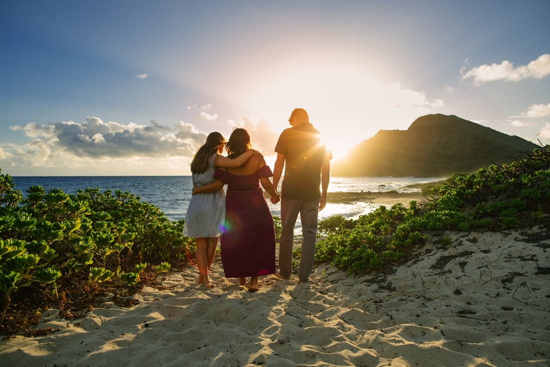 family walking on the beach at sunrise in oahu