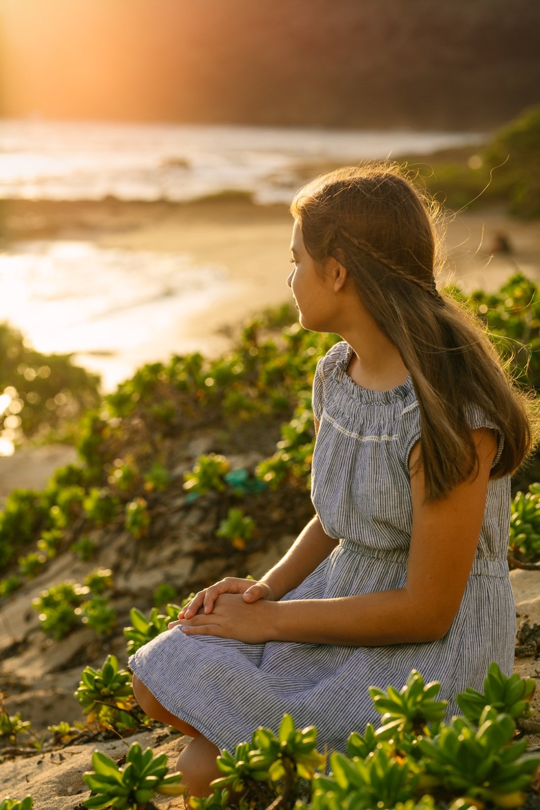 portrait of a girl sitting on the dunes at sunrise oahu hawaii