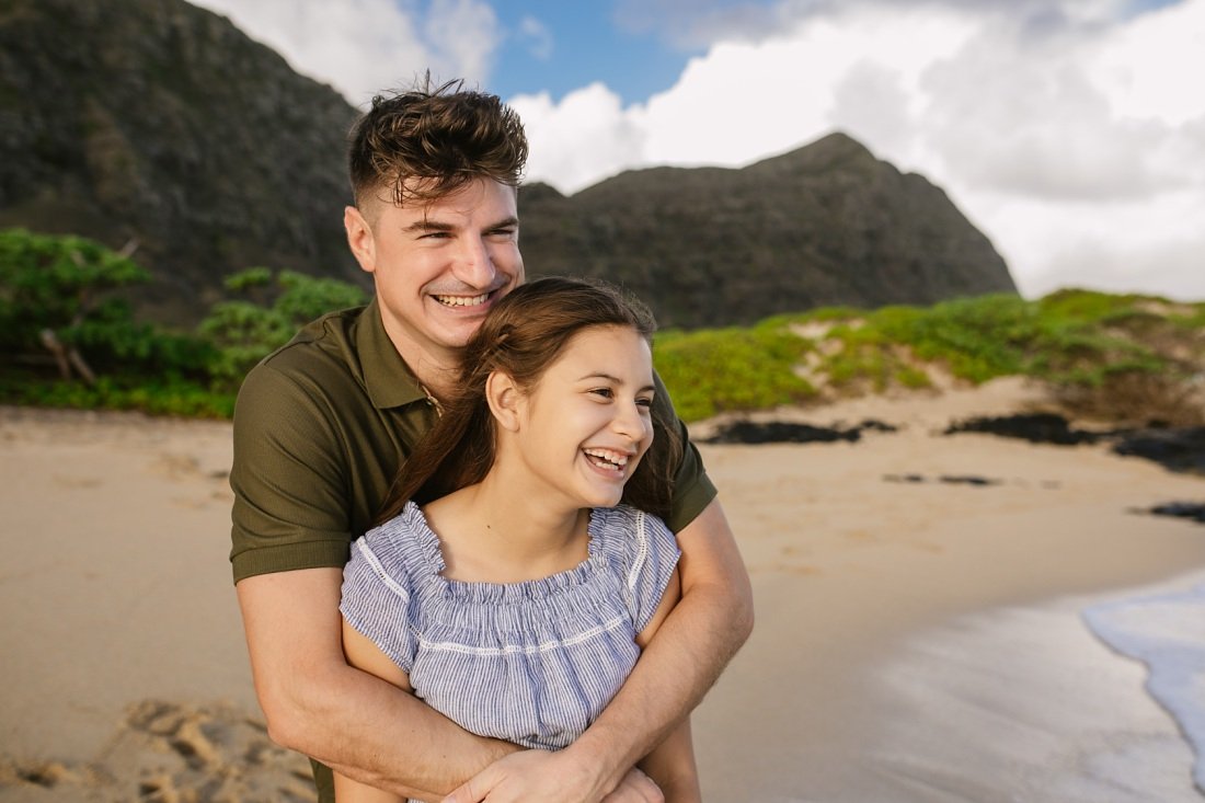 dad and daughter share a laugh at an oahu family beach photo session