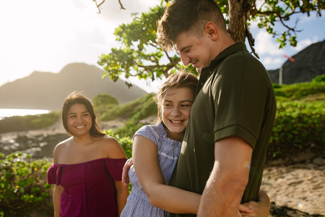 tween daughter hugs dad during a family photography session in oahu