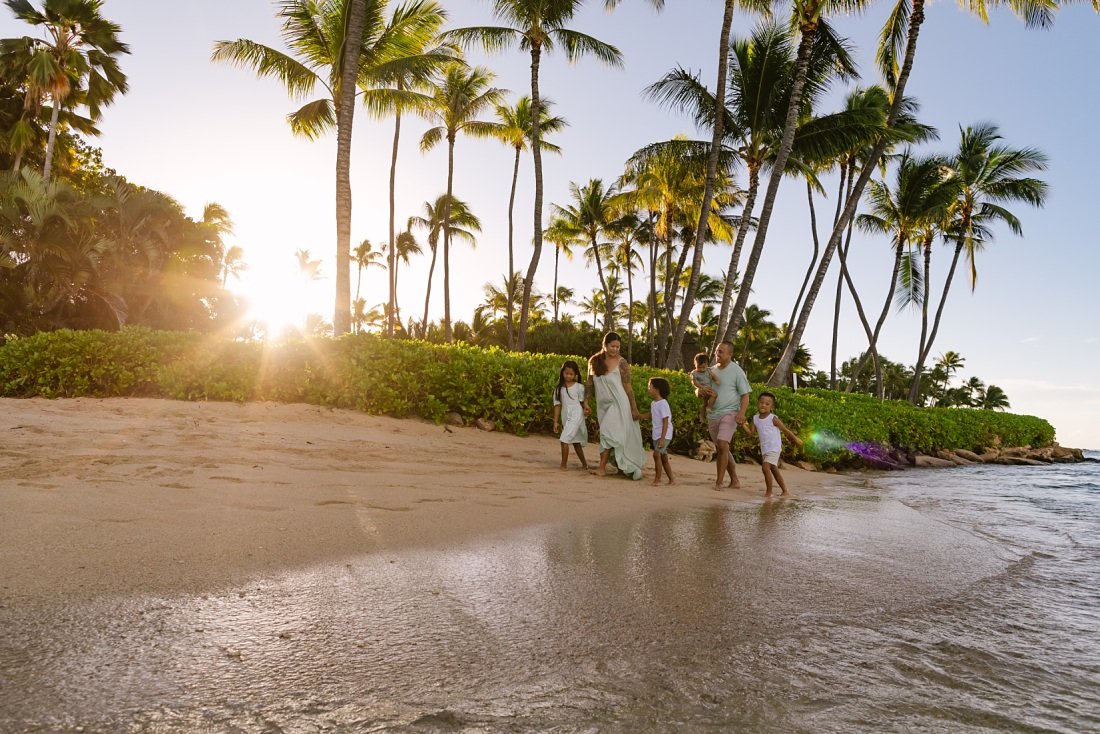 family walking on the beach in koolina at sunrise by Family Photographers on Oahu
