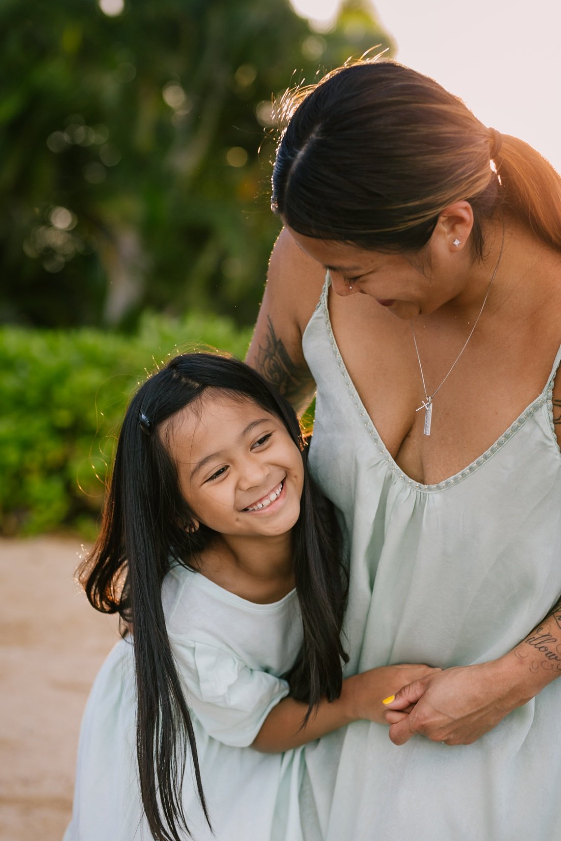 laughing mom and daughter portrait at the beach in hawaii